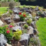 Sloped Backyard Landscaping with Boulders and Flowe