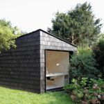 Garden studio has a dark, rough exterior and a light-filled interi