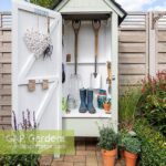 Mini wooden garden shed filled with garden tools | Outdoor garden .